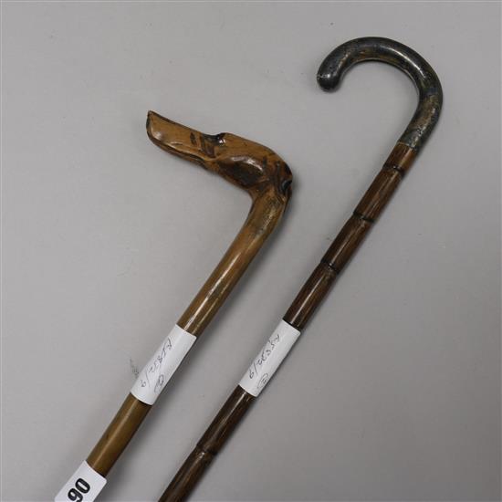 A carved wood Hounds head walking cane and a silver handled walking cane